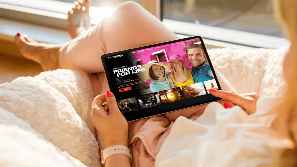 Tablette sur un canapé en Suisse avec un abonnement IPTV Suisse